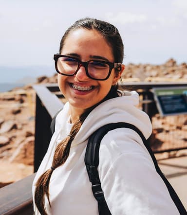 a smiling woman taking a selfie outdoors